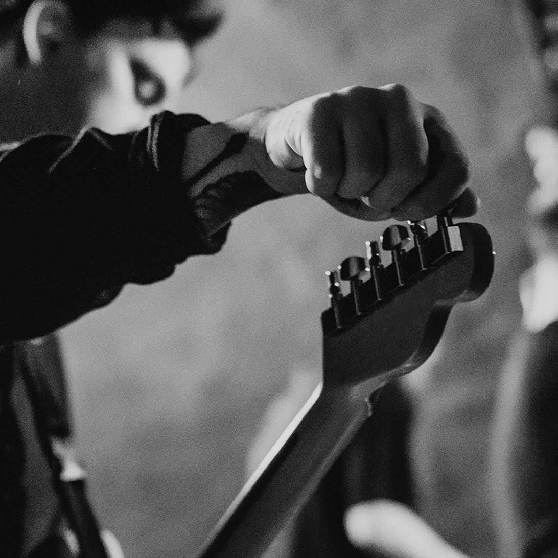 Close-up of a hand tuning a guitar